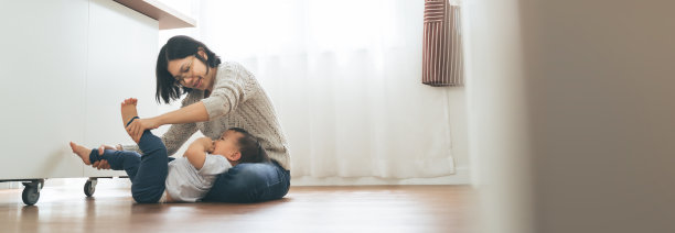 日本母亲和小男孩在地板上玩耍，快乐的亚洲家庭在室内玩得很开心图片下载