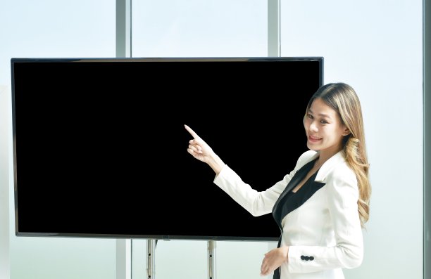 美丽的亚洲女商人在办公室的电视屏幕上展示工作图片下载