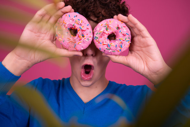 年轻的帅哥和甜甜圈。图片下载