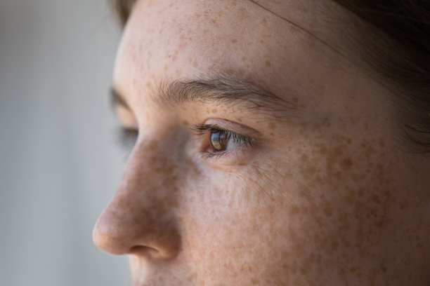 侧视脸的雀斑严肃沉思的女人盯着一旁图片下载