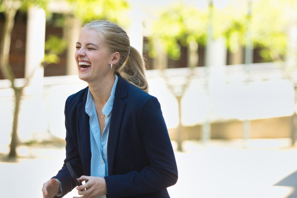 一个年轻的女商人在城市里笑图片下载