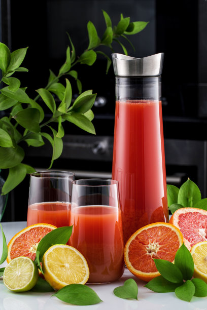 新鲜的葡萄柚，玻璃杯和一壶葡萄柚汁。特写镜头。图片下载