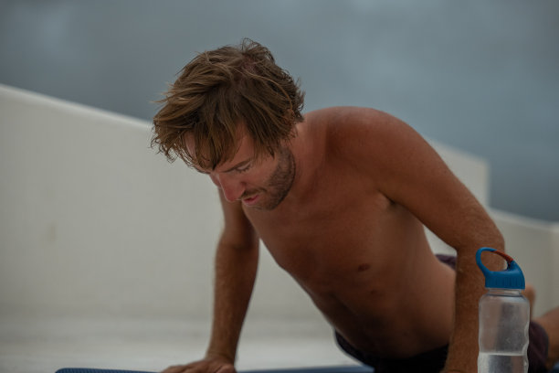 年轻人在屋顶上锻炼，暴风雨即将来临图片下载