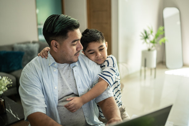 父亲在家里用笔记本电脑工作，和儿子聊天图片下载