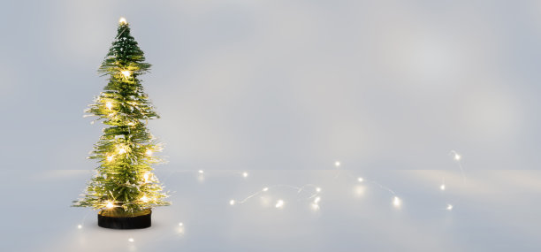 明亮的圣诞树装饰在抽象冰冷的房间与复制空间，闪亮的串灯在白色背景的概念为12月假期图片下载