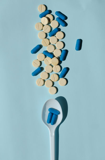 桌上放着五颜六色的胶囊。勺子用药物。医学的疾病。维生素和生物活性添加剂。医学和医疗保健。图片下载