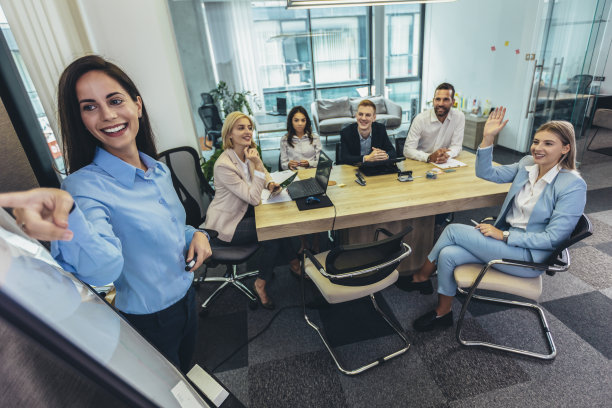 一个女商人在会议室的白板上给她的同事做演示图片下载