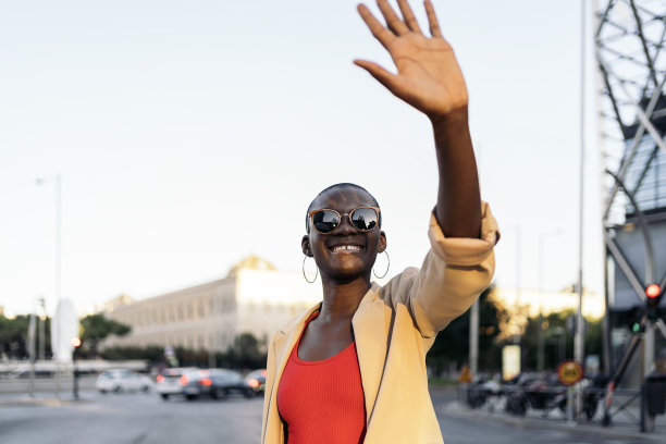 年轻女子戴着太阳镜，用手在户外保护脸部免受阳光的照射图片下载