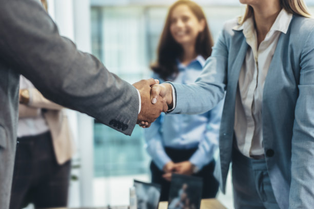 两个商人在办公室开会时握手的镜头图片下载