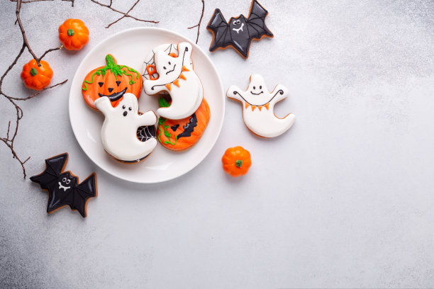 万圣节姜饼饼干在白色盘子上的石头背景。万圣节派对自制饼干。本空间图片下载