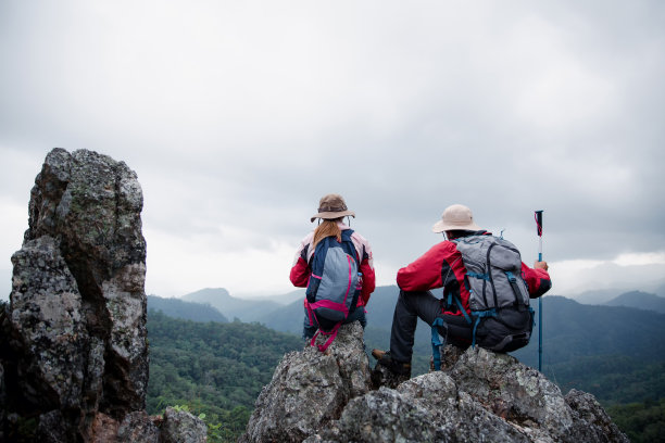 年轻的游客夫妇在高山上观看壮观的山景。山顶上的男女徒步旅行者。一对相爱的旅行者。爱旅行。本空间图片下载