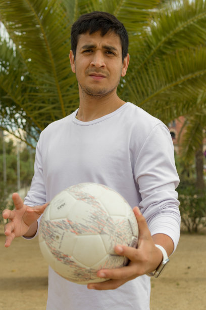 一名秘鲁男子抱着足球，看着相机图片下载