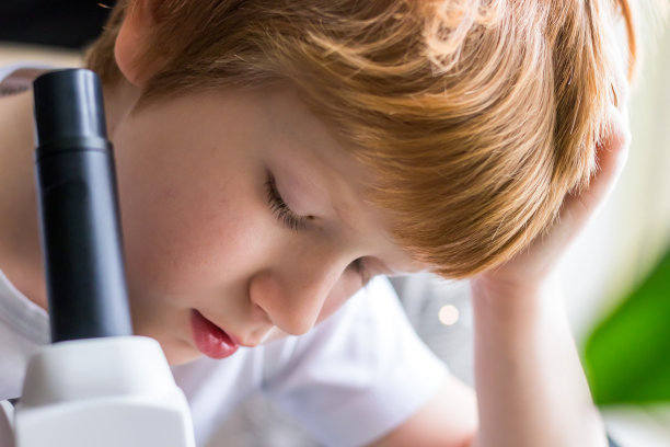 用实验室显微镜拍摄学生的脸部特写图片下载