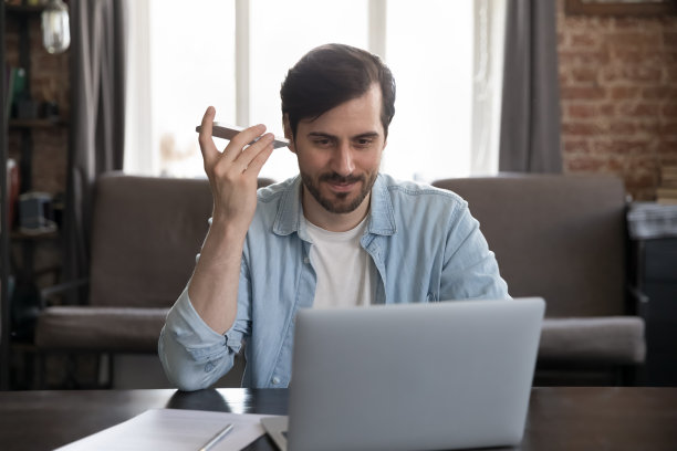 积极的自由职业者男子从智能手机在家里听音频图片下载