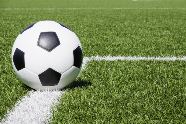 足球在绿色合成人造草地足球运动场上有白色的边角条纹线图片下载