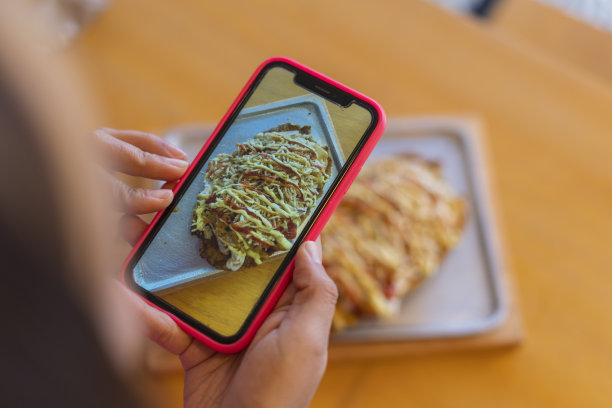 在一家餐厅用餐的拉丁裔顾客正在为她的餐盘拍照图片下载