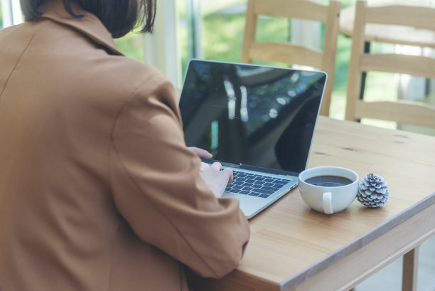 靠近女商人手打字笔记本电脑喝黑咖啡杯在绿色花园咖啡馆。汉兹女士喜欢在家工作时喝热咖啡。商务女士要黑咖啡或热巧克力咖啡图片下载