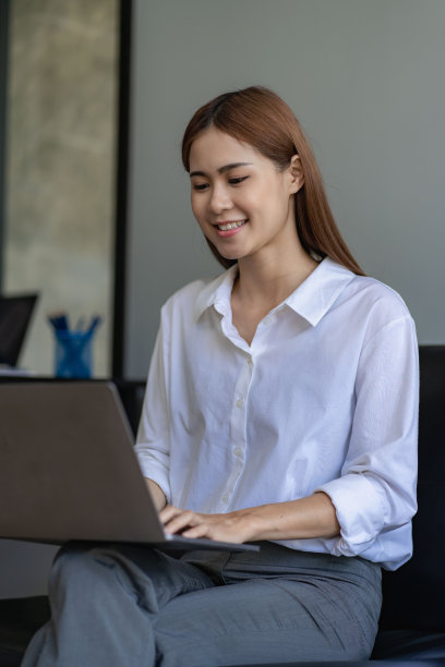 亚洲女性在家里用笔记本电脑上网工作、上网、通过视频电话与人打招呼。图片下载