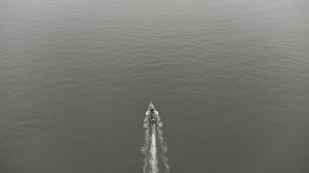 无人机拍摄的泰国传统长尾渔船在海上航行的鸟瞰图。海洋中快速移动的渔船的俯视图。图片下载