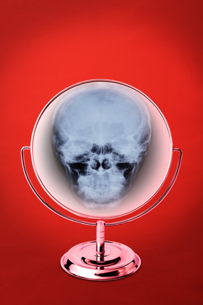 红色背景上阴森的镜子反射出骷髅图片下载