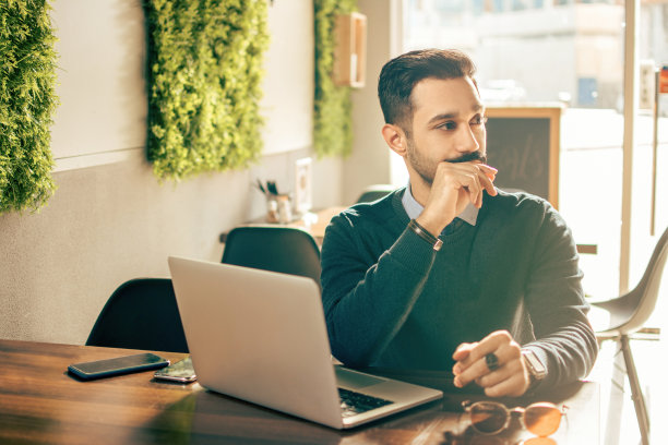 年轻印度男人在咖啡馆使用笔记本电脑图片下载