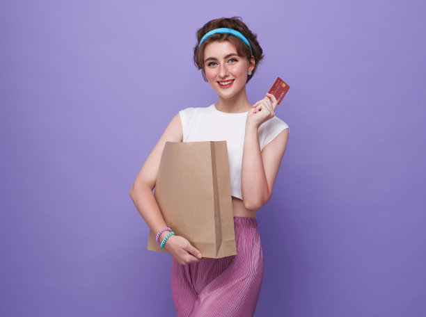 年轻的微笑的美丽的女人展示信用卡在手显示信任和信心进行支付。图片下载