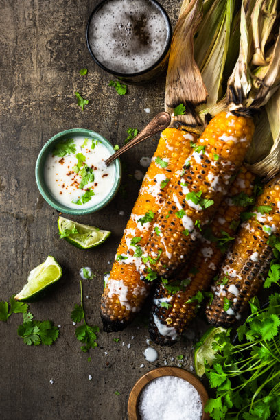 烤玉米棒，配上啤酒、盐、香菜和酸橙图片下载