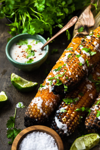 烤玉米棒，配上啤酒、盐、香菜和酸橙图片下载