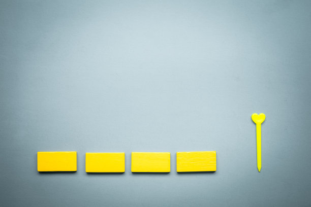 木制黄色方块排成一排和心形。图片下载