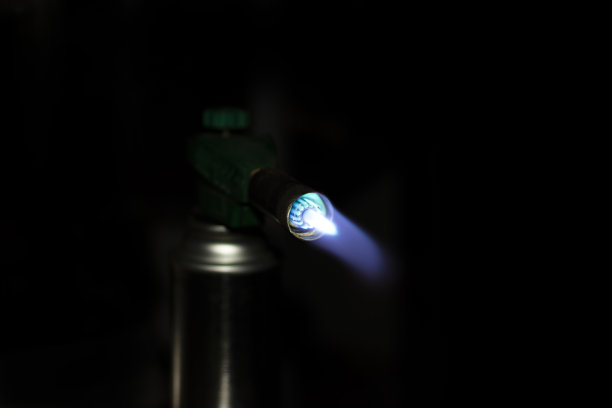 便携式气瓶与燃烧的燃烧器在一个黑暗的背景图片下载