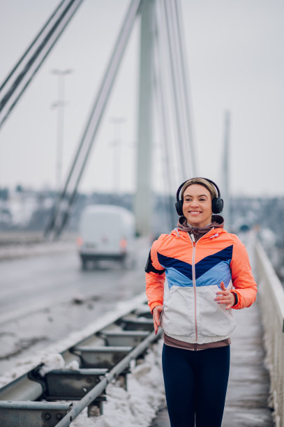 冬雪中，女子在桥上奔跑。图片下载