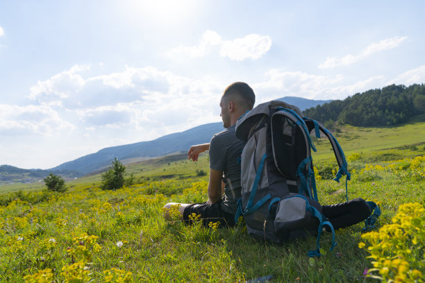 年轻人坐在太阳谷上看着图片下载