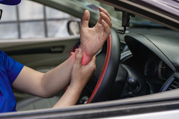 年轻司机腕部疼痛，长途驾驶概念图片下载