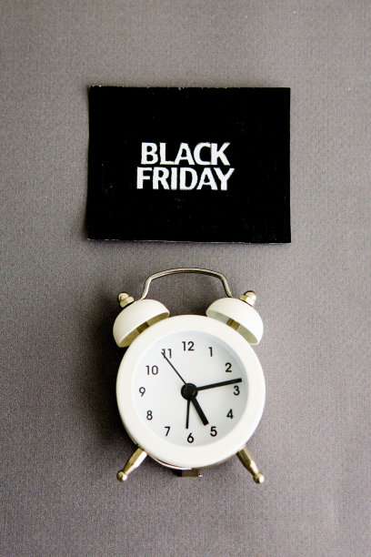 白色闹钟和黑色方块上的铭文——灰色背景的黑色星期五。销售的话题。图片下载