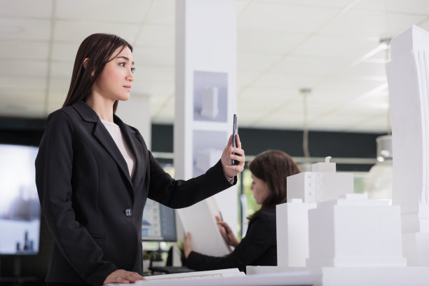 建筑师在智能手机上拍摄建筑3d打印模型照片图片下载