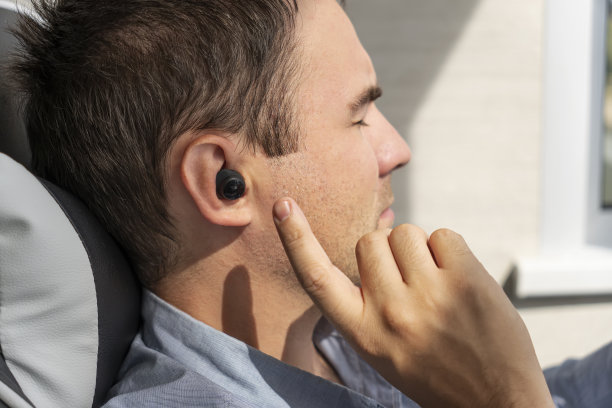 无线耳机在人耳中的特写。把耳机插入耳朵。戴着耳机听音乐。图片下载