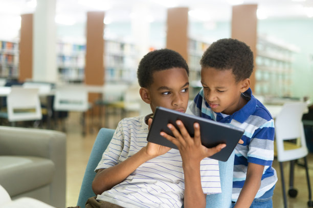 两个男孩一起看平板电脑图片下载