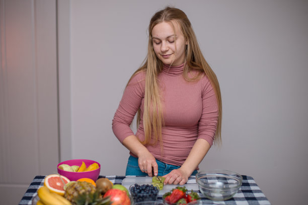 小女孩做新鲜水果沙拉，切片水果和准备沙拉图片下载