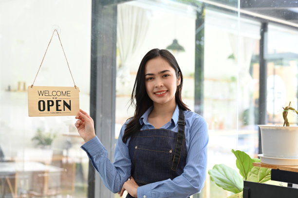 站在门口的美丽年轻的亚洲女咖啡店老板或咖啡师图片下载