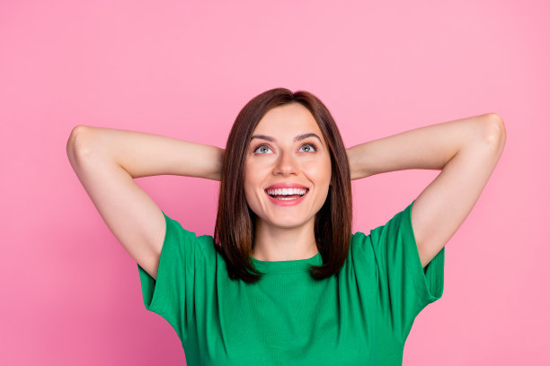 照片的年轻美丽的完美女人仰望梦想着丰富的未来孤立在粉红色的背景图片下载