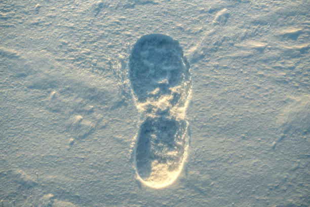 夕阳下雪地纹理上的脚印图片下载