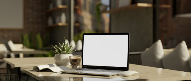 笔记本电脑模型，书和咖啡杯在舒适的咖啡店座位空间的桌子上图片下载