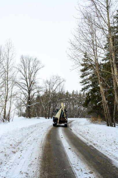 拖拉机正行驶在雪路上。城市街道除雪。图片下载