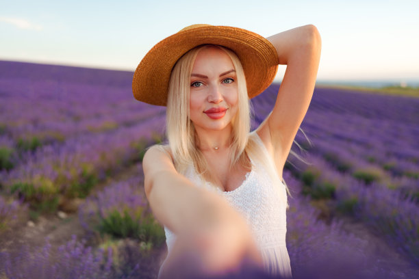 迷人的年轻女子穿着夏装站在薰衣草田中图片下载