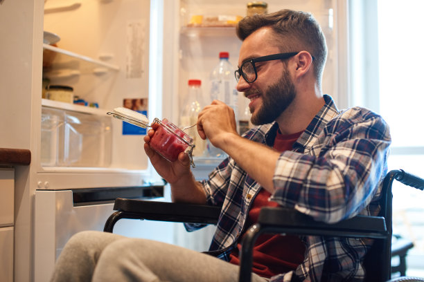 坐轮椅的人在冰箱里吃东西图片下载