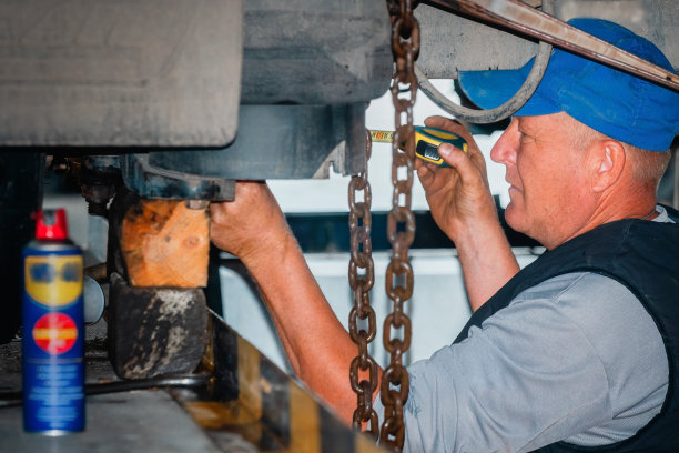 真正的卡车修理工人修理机器。汽车修理工在工作的肖像。卡车悬挂维修。图片下载