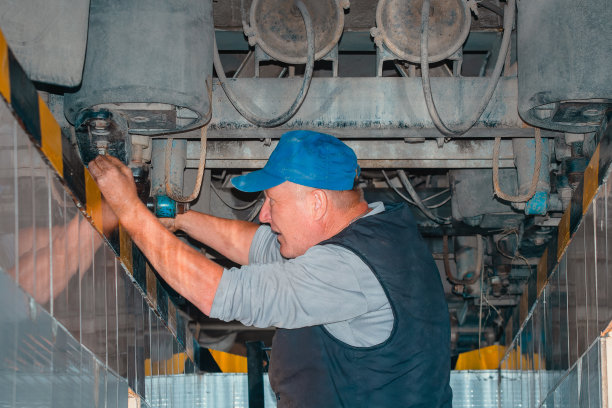 汽车修理工站在汽车检修坑里修理卡车。真正的锁匠是修理卡车的。图片下载