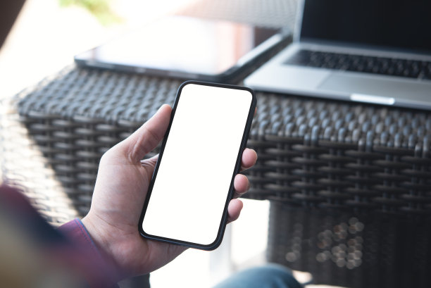 手机空白白屏模型。男人双手握着，用手机在办公室背景，广告模板图片下载