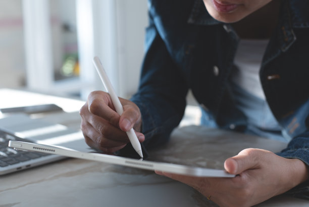 近距离的亚洲妇女手与触控笔使用数字平板电脑触摸触摸屏图片下载