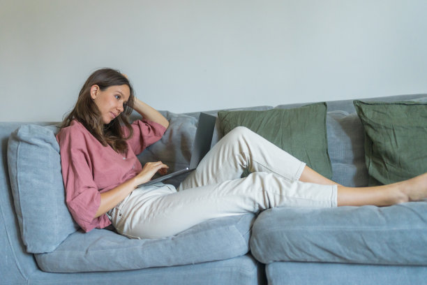 女人在沙发上用笔记本电脑工作图片下载